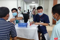 Bác sĩ khám sàng lọc cho người dân trước khi tiêm vaccine phòng COVID-19 (Ảnh - Minh Thuý) 