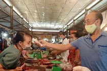 Cán bộ kiểm tra nhiệt độ cho người bán hàng ở chợ (Ảnh - UBND Q. Ba Đình) 