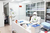 Nhân viên y tế làm việc trong phòng lấy mẫu (Ảnh - Minh Thuý) 