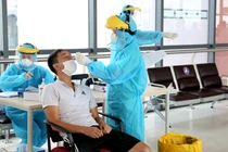 Nhân viên y tế lấy mẫu xét nghiệm COVID-19 cho người dân (Ảnh - Xuân Hải) 