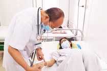 PGS.TS. Đỗ Duy Cường khám cho bệnh nhân mắc sốt xuất huyết (Ảnh - BVCC) 