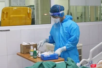 Nhân viên y tế kiểm tra thuốc cho bệnh nhân (Ảnh - Minh Thuý) 