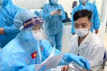 Nhân viên y tế kiểm tra hồ sơ chuẩn bị tiêm vaccine phòng COVID-19 (Ảnh - Tuấn Dũng) 