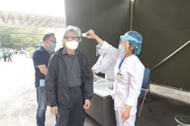 Nhân viên y tế kiểm tra thân nhiệt cho người dân (Ảnh: Minh Thuý) 