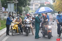 Người dân xuất trình giấy tờ chờ qua chốt kiểm soát phòng dịch COVID-19 (Ảnh - Minh Thuý) 