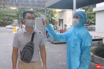 Nhân viên y tế kiểm tra nhiệt độ của người dân trước khi vào bệnh viện (Ảnh - Minh Thuý) 