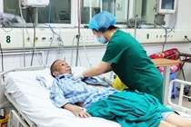 Bác sĩ chăm sóc cho bác gái bệnh nhân 17 mắc COVID-19 nặng. Ảnh: Minh Thúy 