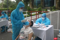 Nhân viên y tế lấy mẫu xét nghiệm COVID-19 cho người dân (Ảnh - Minh Thuý) 