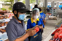 Người dân mua thực phẩm thiết yếu (Ảnh - Ngọc Thắng) 