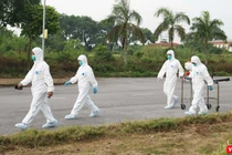 Nhân viên y tế chuẩn bị phun khử khuẩn phòng COVID-19 (Ảnh - Minh Thuý) 