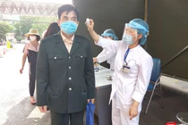 Kiểm tra thân nhiệt cho người dân trước khi vào bệnh viện (Ảnh - Minh Thuý) 