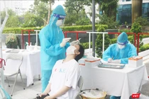 Nhân viên y tế lấy mẫu xét nghiệm COVID-19 cho người dân (Ảnh - Minh Thuý)