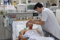 TS.BS. Nguyễn Tiến Dũng - Trung tâm Chống độc, Bệnh viện Bạch Mai khám bệnh cho một bệnh nhân ngộ độc methanol (Ảnh: Mai Thanh) 