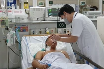 TS.BS. Nguyễn Tiến Dũng - Trung tâm Chống độc, Bệnh viện Bạch Mai khám bệnh cho một bệnh nhân ngộ độc methanol (Ảnh: Mai Thanh) 