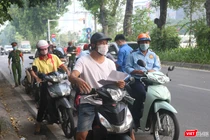 Người dân xếp hàng chờ kiểm tra giấy đi đường (Ảnh - Minh Thuý) 