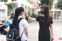 Cô giáo đo nhiệt độ cho học sinh (Ảnh- Minh Thuý) 