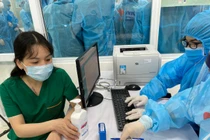 Nhân viên y tế kiểm tra hồ sơ, chuẩn bị tiêm vacicne phòng COVID-19 (Ảnh - Tuấn Dũng) 