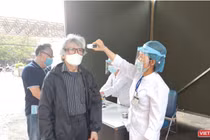 Nhân viên y tế kiểm tra nhiệt độ của người dân (Ảnh - Minh Thuý) 