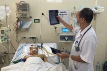 PGS.TS Đỗ Duy Cường thăm khám cho bệnh nhân tại Trung tâm Bệnh Nhiệt đới, Bệnh viện Bạch Mai (Ảnh: Mai Thanh) 