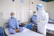 Bác sĩ thăm hỏi tình hình sức khoẻ bệnh nhân ung thư đang điều trị ở Bệnh viện K (Ảnh - BVCC) 