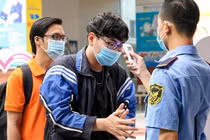  Sinh viên Đại học Công nghệ TPHCM được đo thân nhiệt, rửa tay bằng nước sát khuẩn trước khi vào trường. Ảnh: VNE