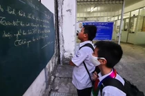 Học sinh Trường THCS - THPT Sương Nguyệt Anh (Q.10, TP.HCM) xem thông báo nghỉ học tránh dịch - Ảnh: Như Hùng 