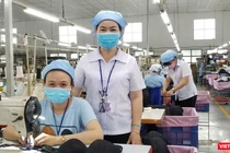 Chị Lê Thị Ngọc Thạnh (đứng) và nữ công nhân Phạm Thị Trinh, người đã gửi con nhỏ về quê, tình nguyện "ba tại chỗ" để giữ dây chuyển sản xuất