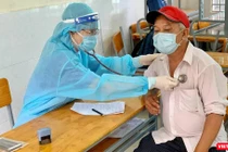 Khám sàng lọc trước khi tiêm chủng COVID-19 cho người dân - Ảnh: HCDC