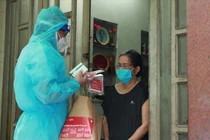 Phát thuốc điều trị F0 tại nhà. Ảnh: HCDC 