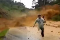 Người đi đường thất thần tháo chạy khỏi đống đất đá từ trên cao đổ xuống (ảnh cắt từ clip)