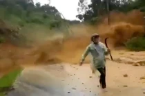 Người đi đường thất thần tháo chạy khỏi đống đất đá từ trên cao đổ xuống (ảnh cắt từ clip)