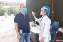 Nhân viên y tế đo nhiệt độ cho người dân trước khi vào Bệnh viện