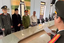 Công an TP Huế tống đạt quyết định khởi tố Hoàng Trung Nghĩa (thứ 2 từ trái sang). Ảnh: Công an cung cấp.