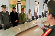 Công an TP Huế tống đạt quyết định khởi tố Hoàng Trung Nghĩa (thứ 2 từ trái sang). Ảnh: Công an cung cấp.