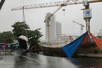 Lực lượng cứu hộ cẩu kéo ô tô bị hố tử thần nuốt chửng.