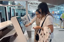 Nhân viên hướng dẫn hành khách sử dụng dịch vụ ký gửi hành lý tự động thông qua việc tích hợp hệ thống quầy tự gửi hành lý (self-bag drop) tại Nhà ga T2 Đà Nẵng