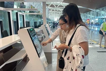 Nhân viên hướng dẫn hành khách sử dụng dịch vụ ký gửi hành lý tự động thông qua việc tích hợp hệ thống quầy tự gửi hành lý (self-bag drop) tại Nhà ga T2 Đà Nẵng