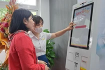 Nhân viên Bệnh viện Đà Nẵng hướng dẫn người bệnh sử dụng Ki-ốt y tế thông minh