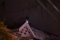 Lính cứu hỏa trèo lên nóc nhà kế bên để cứu hộ cứu nạn.