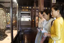 Du khách sử dụng smartphone với chip NFC gắn trên cổ vật trưng tại Cung đình Huế.