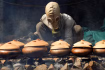 Anh Bùi Văn Cường đeo mặt nạ phòng độc để kho cá trắm (ảnh: Reuters)