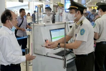 Hành khách sử dụng tài khoản VNeID trên điện thoại để làm thủ tục lên máy bay