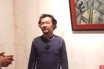 Họa sĩ Huỳnh Lê Nhật Tấn trả lời phỏng vấn tại triển lãm "Vết căn nguyên". Ảnh: Hòa Bình