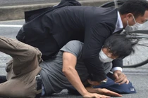 Lực lượng an ninh khống chế nghi phạm Tetsuya Yamagami (áo xám) tại hiện trường vụ nổ súng (Ảnh: AFP)