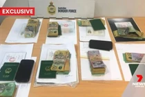 Hình ảnh từ bản tin của 7News thể hiện rõ các cuốn hộ chiếu mang quốc huy Việt Nam trong tang vật vụ việc. (Ảnh cắt từ clip)