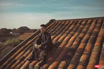 Ca sĩ Đức Tuấn ngồi trên mái nhà tại phố cổ Hội An (ảnh đăng trên Facebook nhân vật)