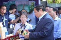 Thủ tướng Phạm Minh Chính trao đổi với 1 bạn sinh viên tại Ngày hội Khởi nghiệp Quốc gia của học sinh, sinh viên.