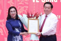 Trưởng Ban Tuyên giáo Trung ương Nguyễn Trọng Nghĩa trao quyết định cho bà Đinh Thị Mai. Ảnh: TTXVN