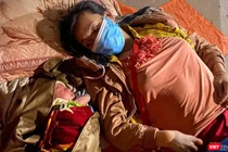 Mẹ con bé trai 10 ngày tuổi nằm nghỉ bên hiên nhà trong chuyền hành trình hơn 1.400km từ TP HCM về quê đi ngang qua Đà Nẵng (ảnh Minh Việt)