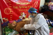 Lực lượng y tế tiêm vaccine phòng COVID-19 cho người cao tuổi, bị bệnh nặng không thể đến điểm tiêm (Ảnh K.Y.)